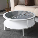 A modern white coffee table with a circular glass top and a lower shelf, placed on a grey carpet.