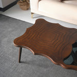 Contemporary designer table with glass top and asymmetric legs
