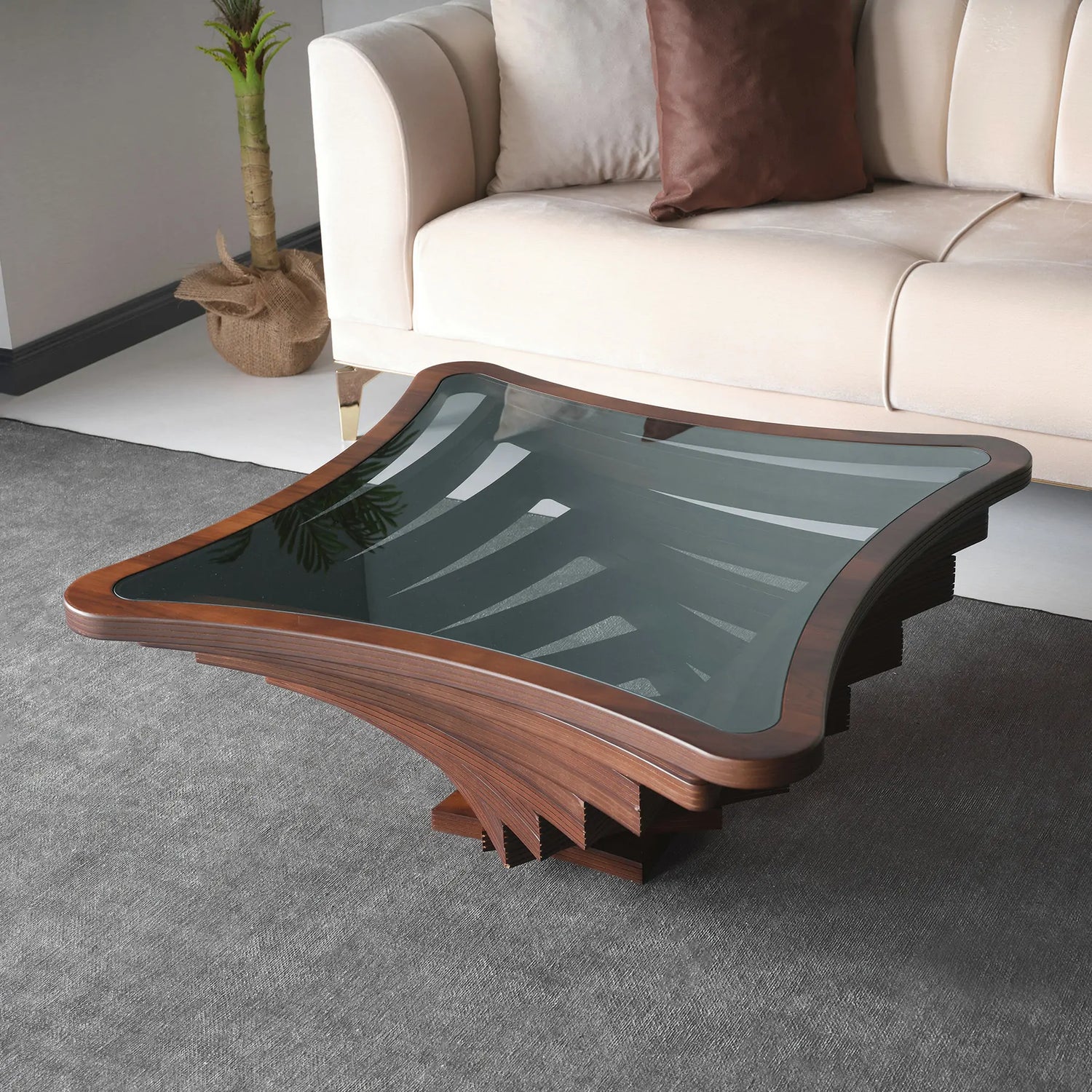 An uniquely designed coffee table with a wood frame and glass top, placed in a living room setting.