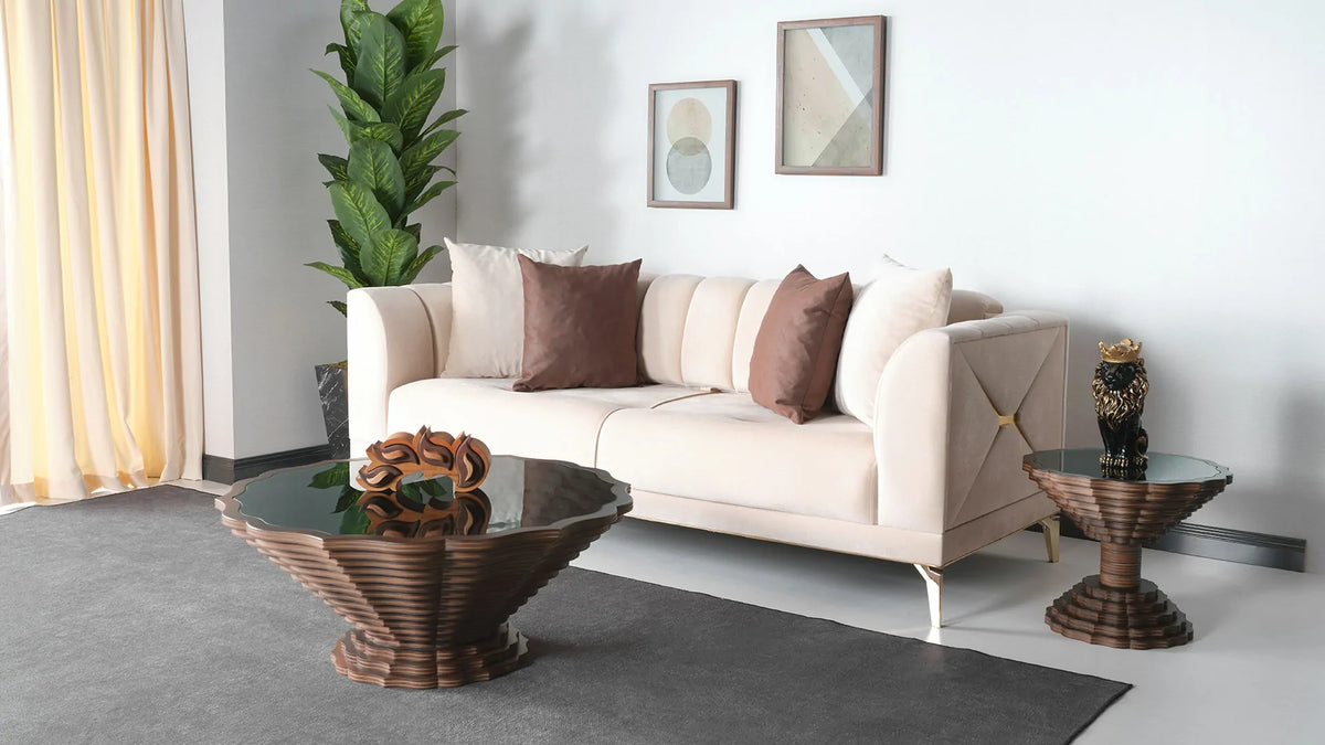 A round wooden side table and coffee table with a scalloped edge design and a dark glass top, placed on a white floor
