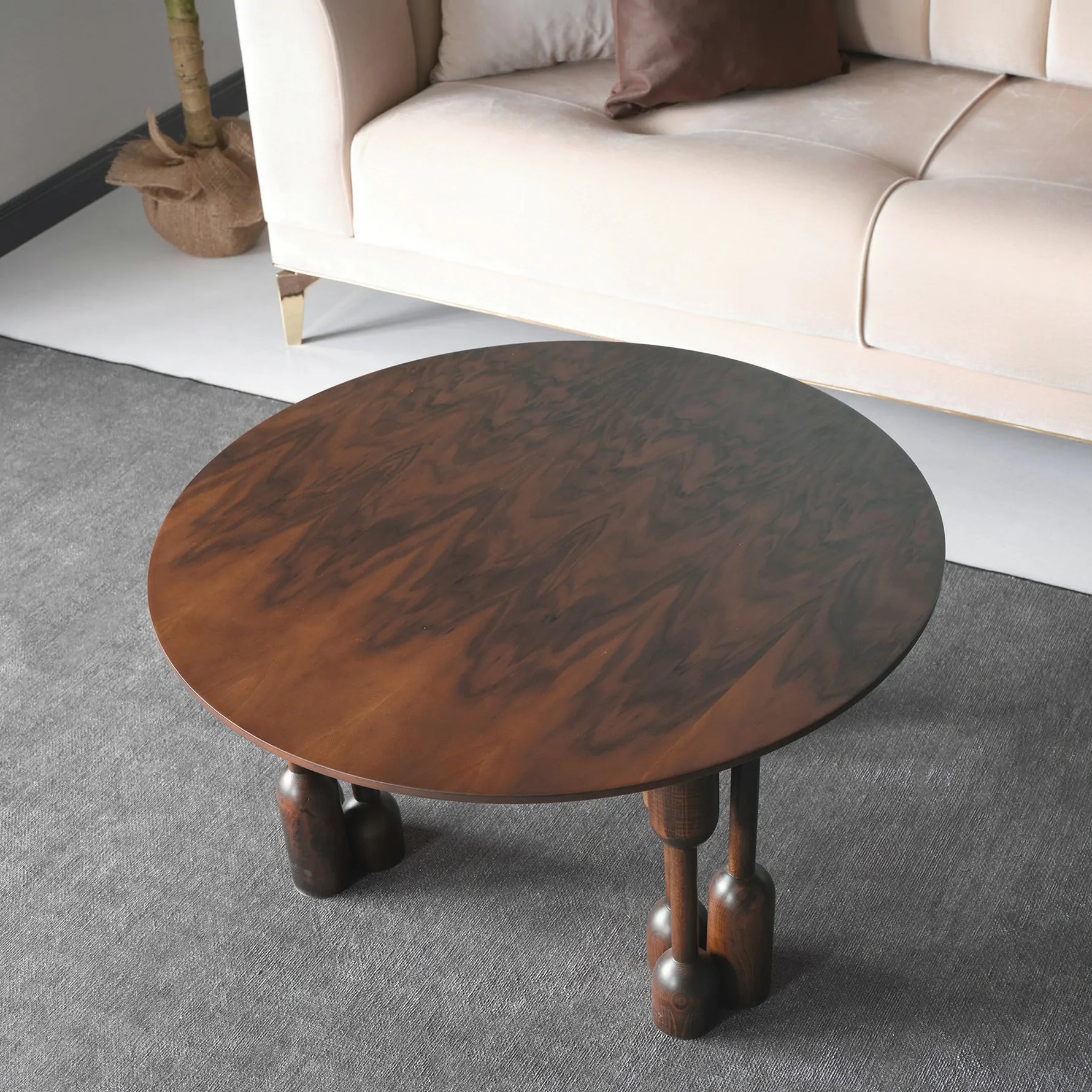 Round wood coffee table with sculptural carved legs