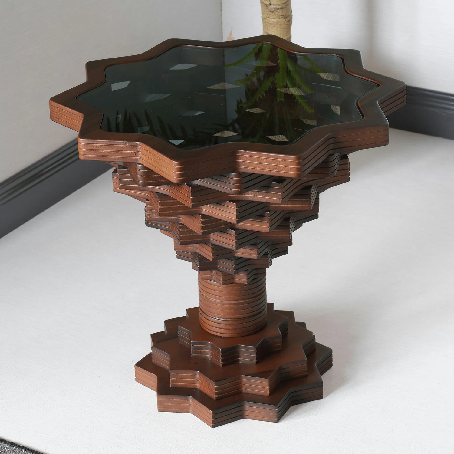 A star-shaped side table with a wooden structure and a dark glass top.