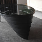 Statement furniture piece with carved wood and smooth glass