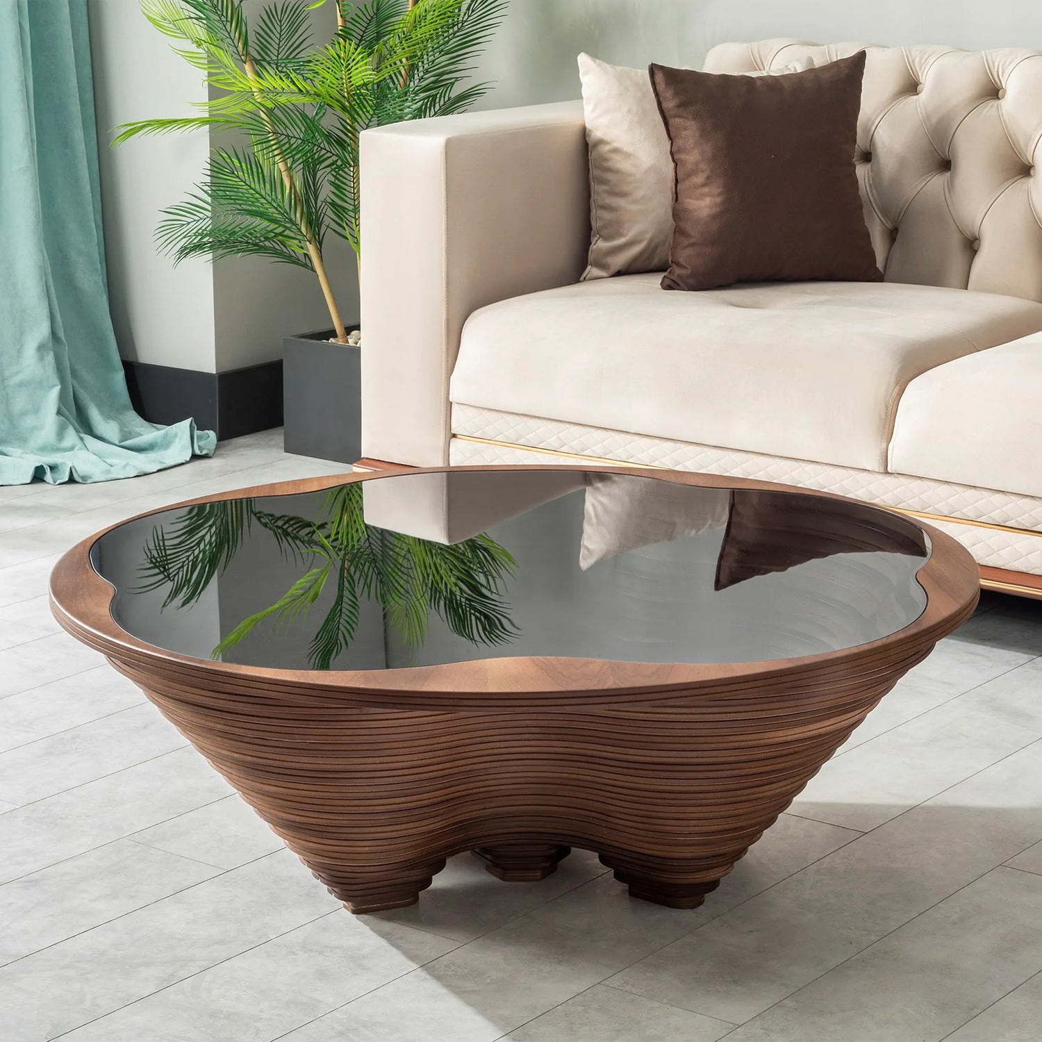 A stylish coffee table with a canyon-inspired 3D design made of layered wood and a tempered glass top, placed in a room with a beige sofa and a decorative plant.