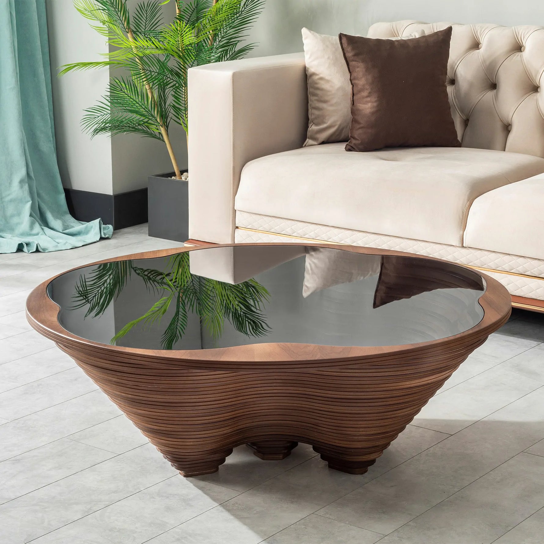 A stylish coffee table with a canyon-inspired 3D design made of layered wood and a tempered glass top, placed in a room with a beige sofa and a decorative plant.