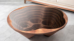"Modern sculptural center table with an organic fluid form and dark tempered glass top."